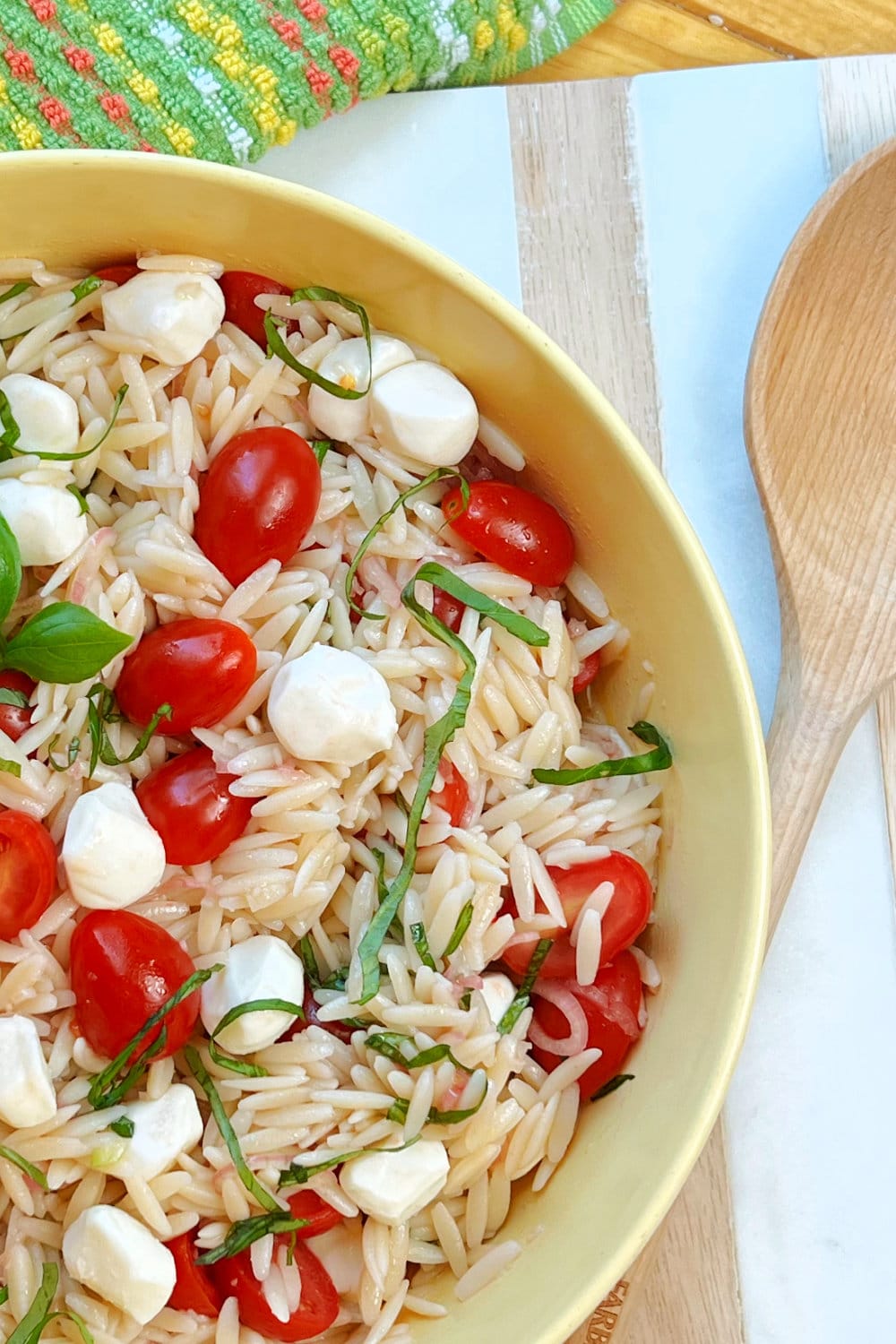 A yellow bowl of Caprese Orzo Pasta Salad. 