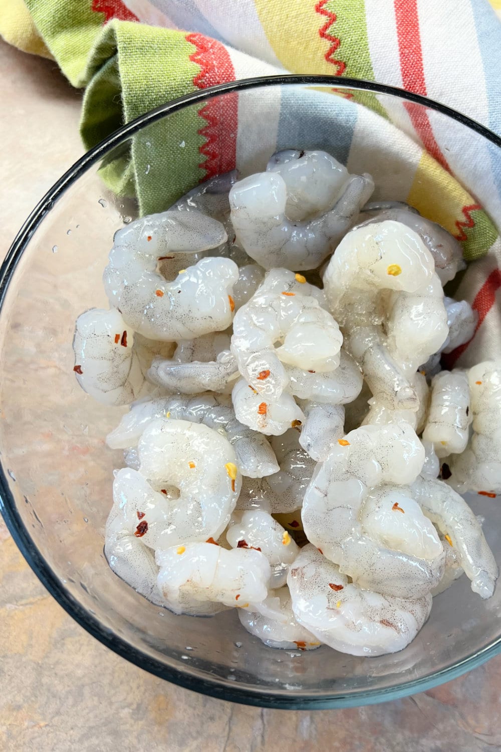 Seasoned shrimp ready to be sauteed in a skillet. 