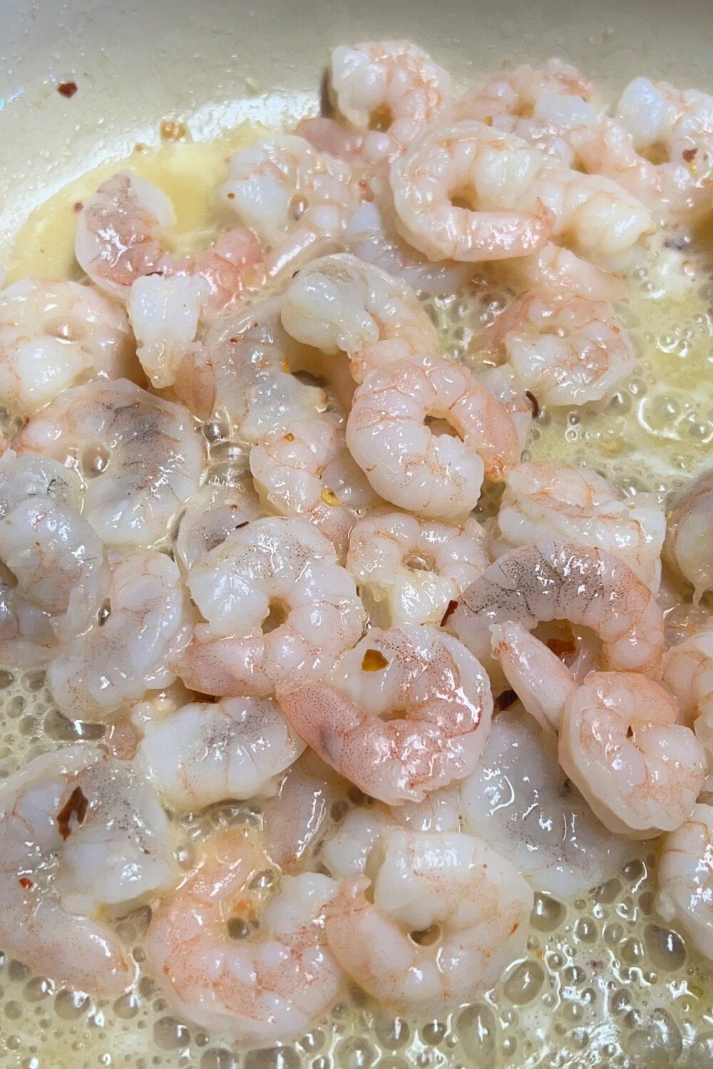 Fully cooked shrimp in a skillet. 