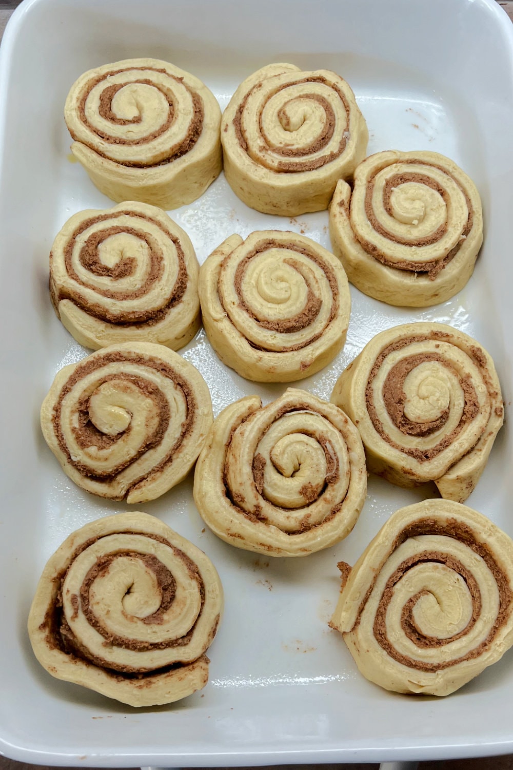 Canned Pillsbury Grands cinnamon rolls placed in a single layer across a 9x13-inch pan. 