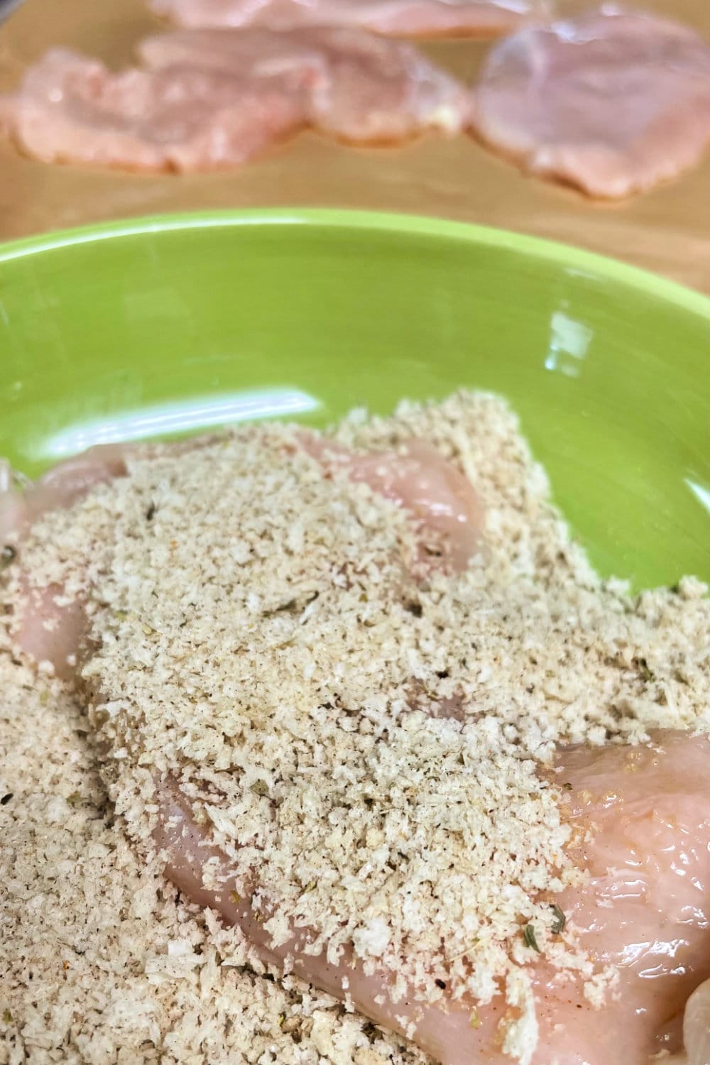 Chicken cutlets being dredged in the Panko coating. 