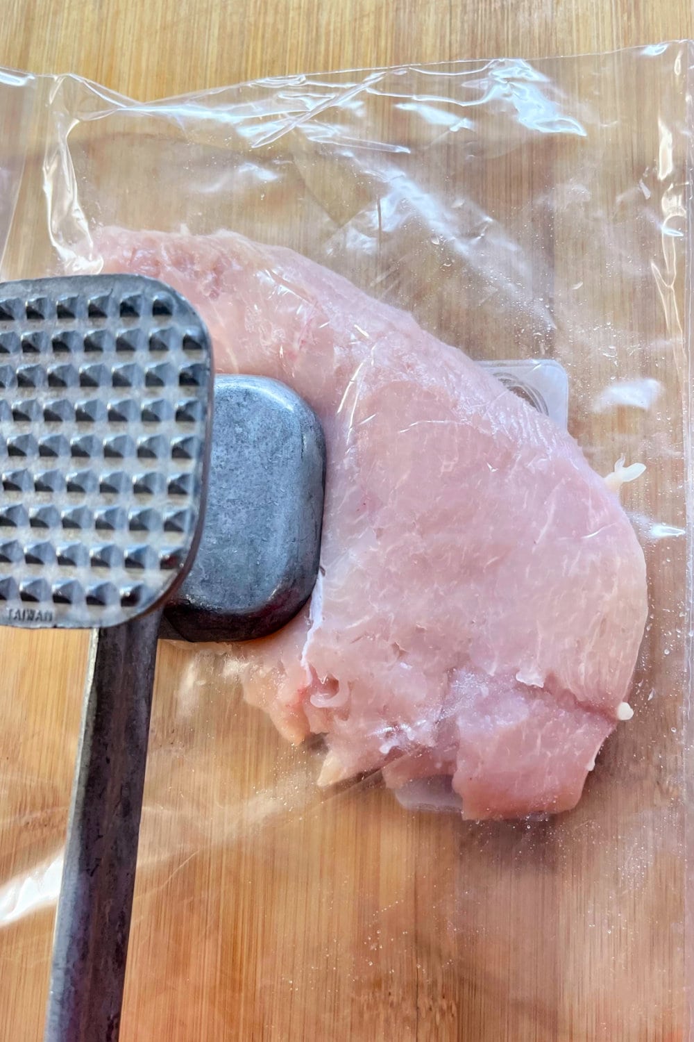 Pounding out the chicken breasts to make cicken cutlets.