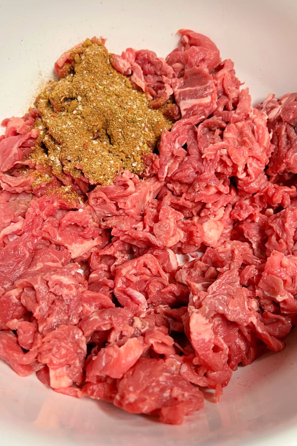 Carne picada meat with a seasoning blend ready to stir in. 