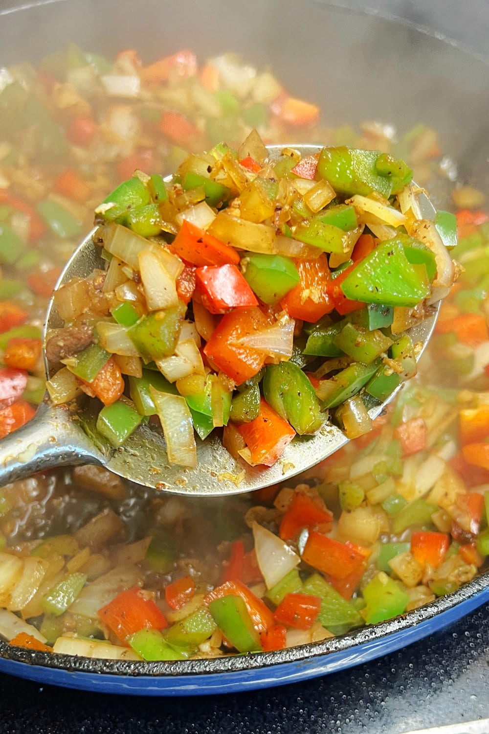 A spoonful of sauteed vegetables for Carne Picada. 