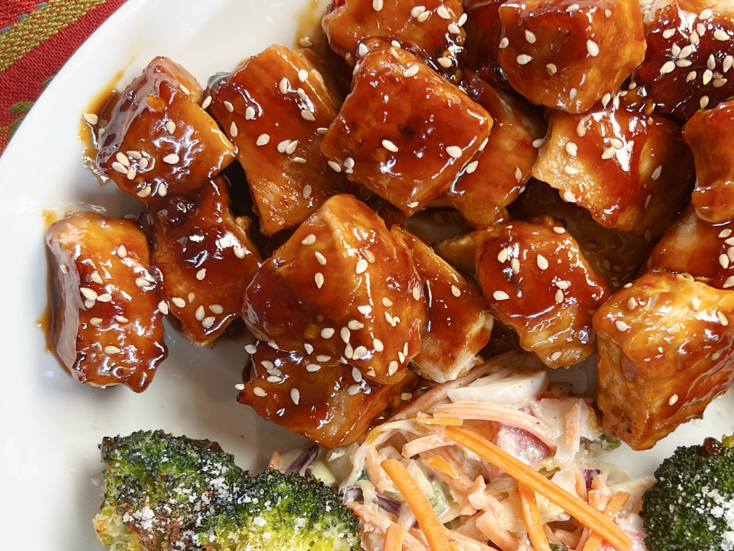 Cubes of pork in an Asian sauce on a white plate. 