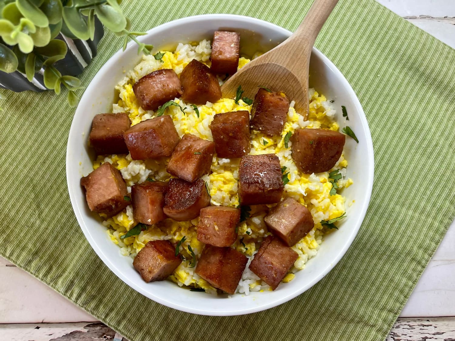 A bowl of Spam Rice and Eggs with a serving spoon.