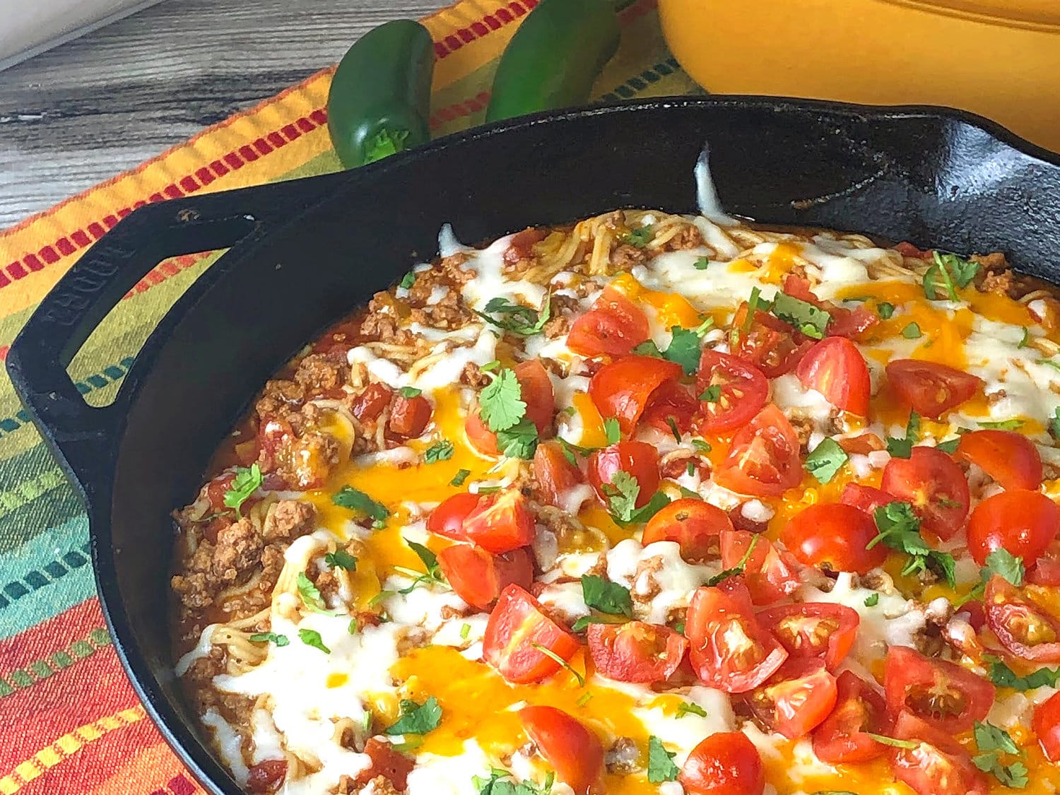 Easy fiesta spaghetti skillet garnished with tomatoes and cilantro