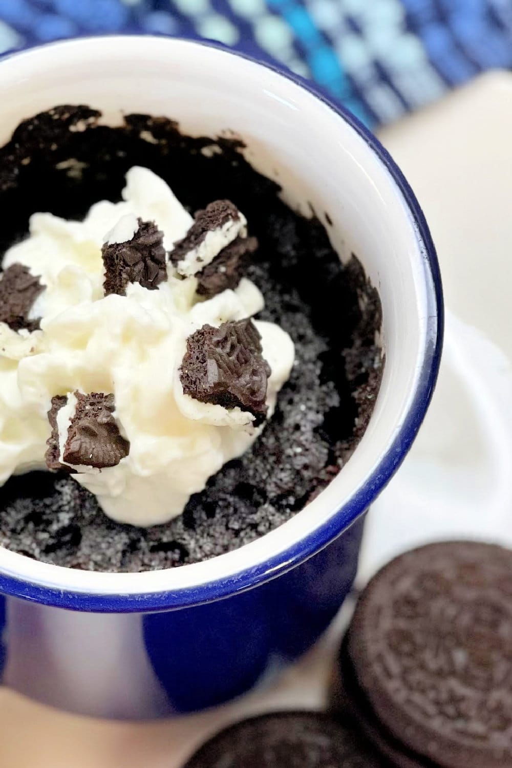 An Oreo Mug Cake garnished with crumbled Oreos.