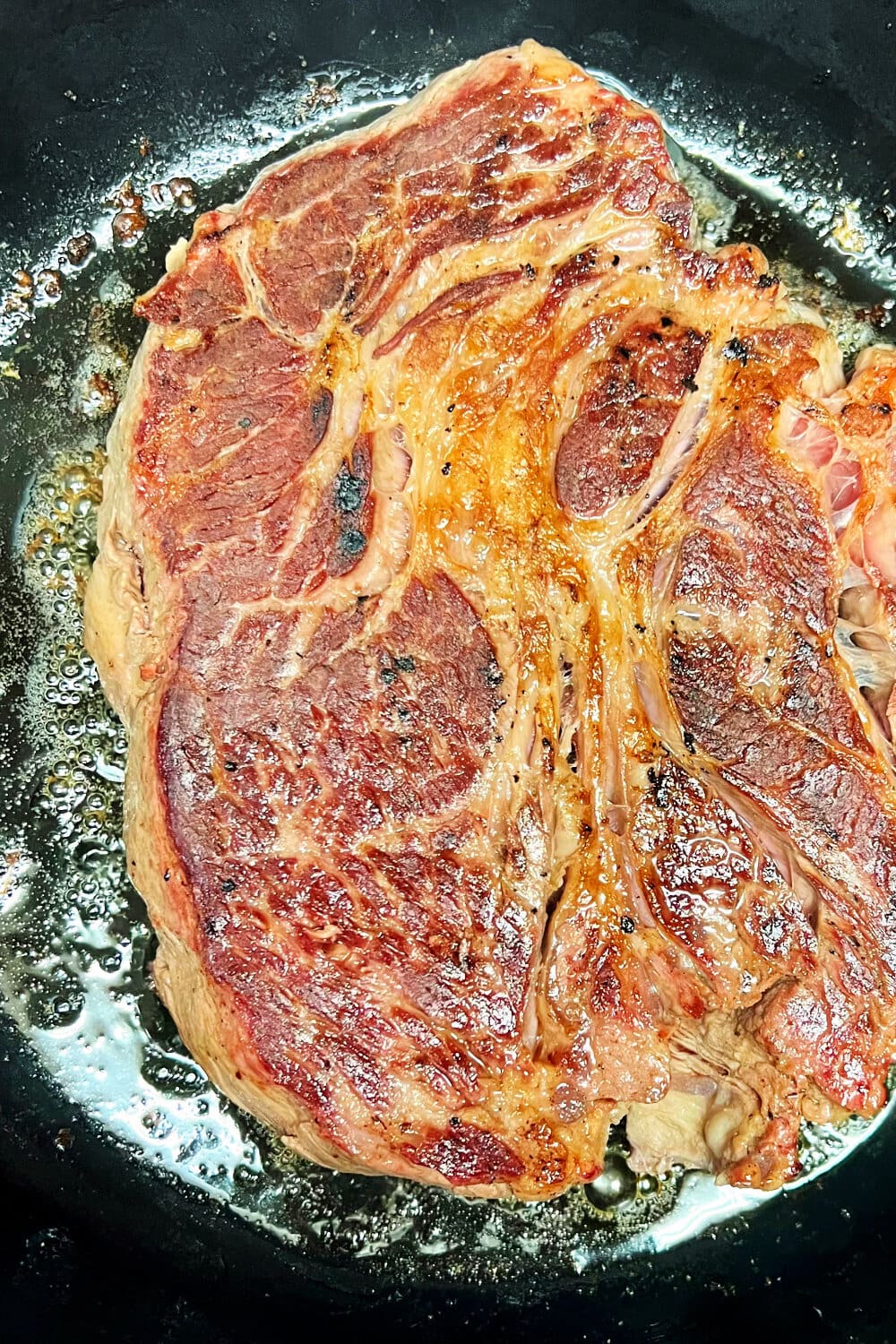 Searing the chuck roast in a cast iron skillet. 