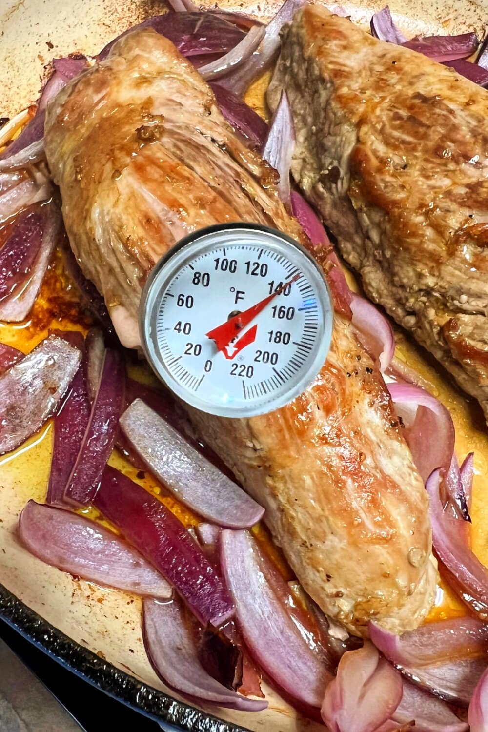 Using an instant-read meat thermometer to take the internal temperature of a pork tenderloin. 