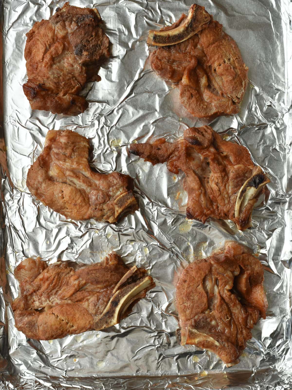 country-style-ribs-asian-no-sauce Partially cooked boneless ribs on a clean foil-lined baking sheet.