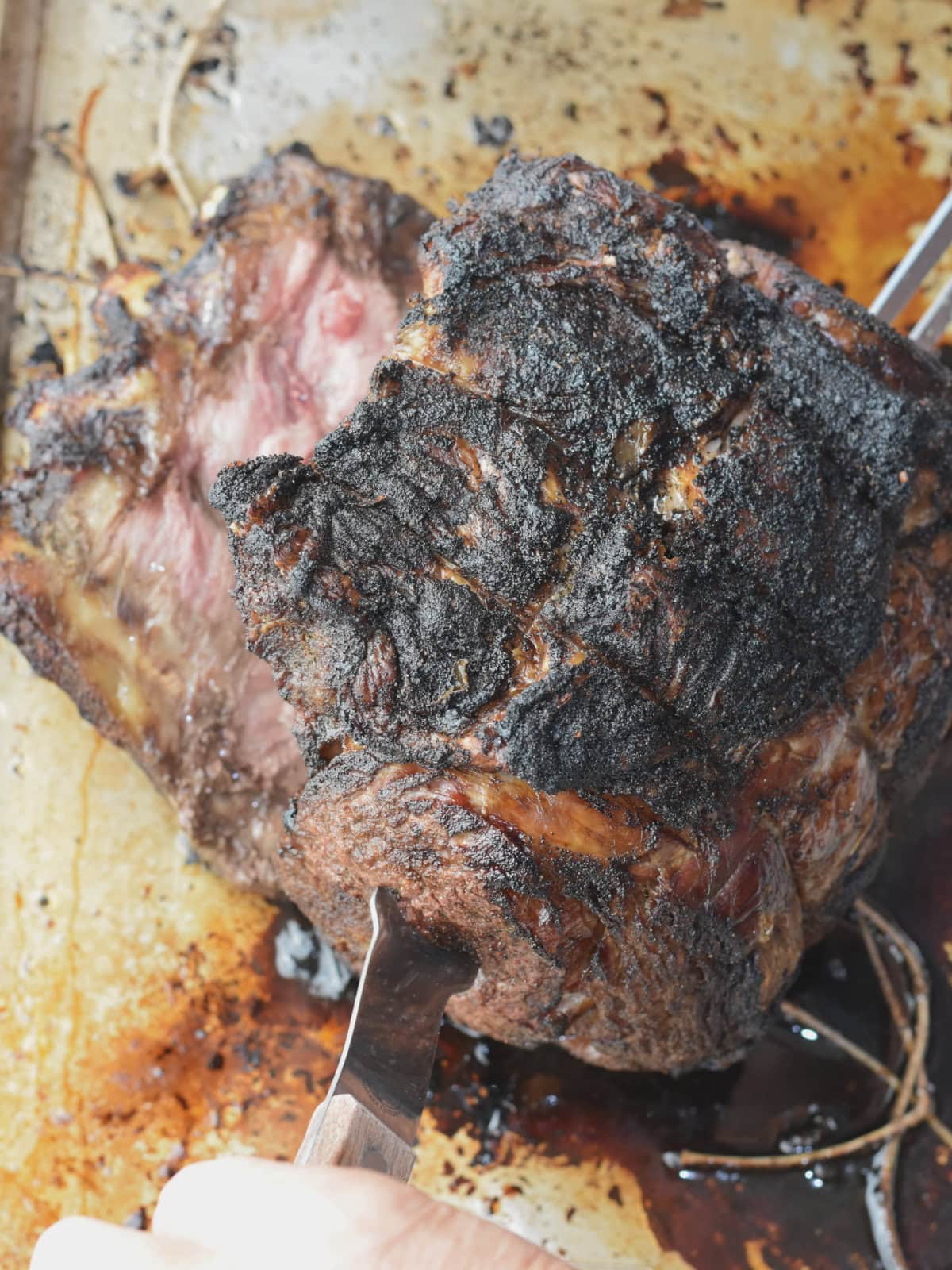 prime-rib-500-rule-lifting Lifting the beef off the bone rack on a sheet pan.