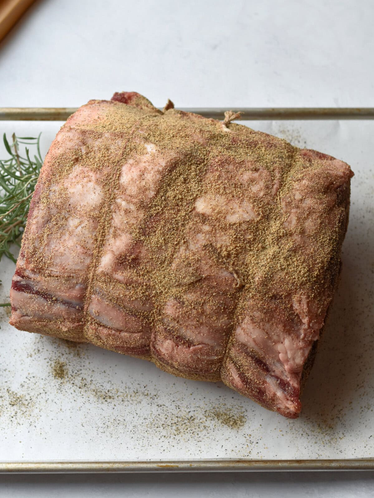 Prime-Rib-500-Rule-Seasoned Seasoned standing rib roast on a sheet pan.