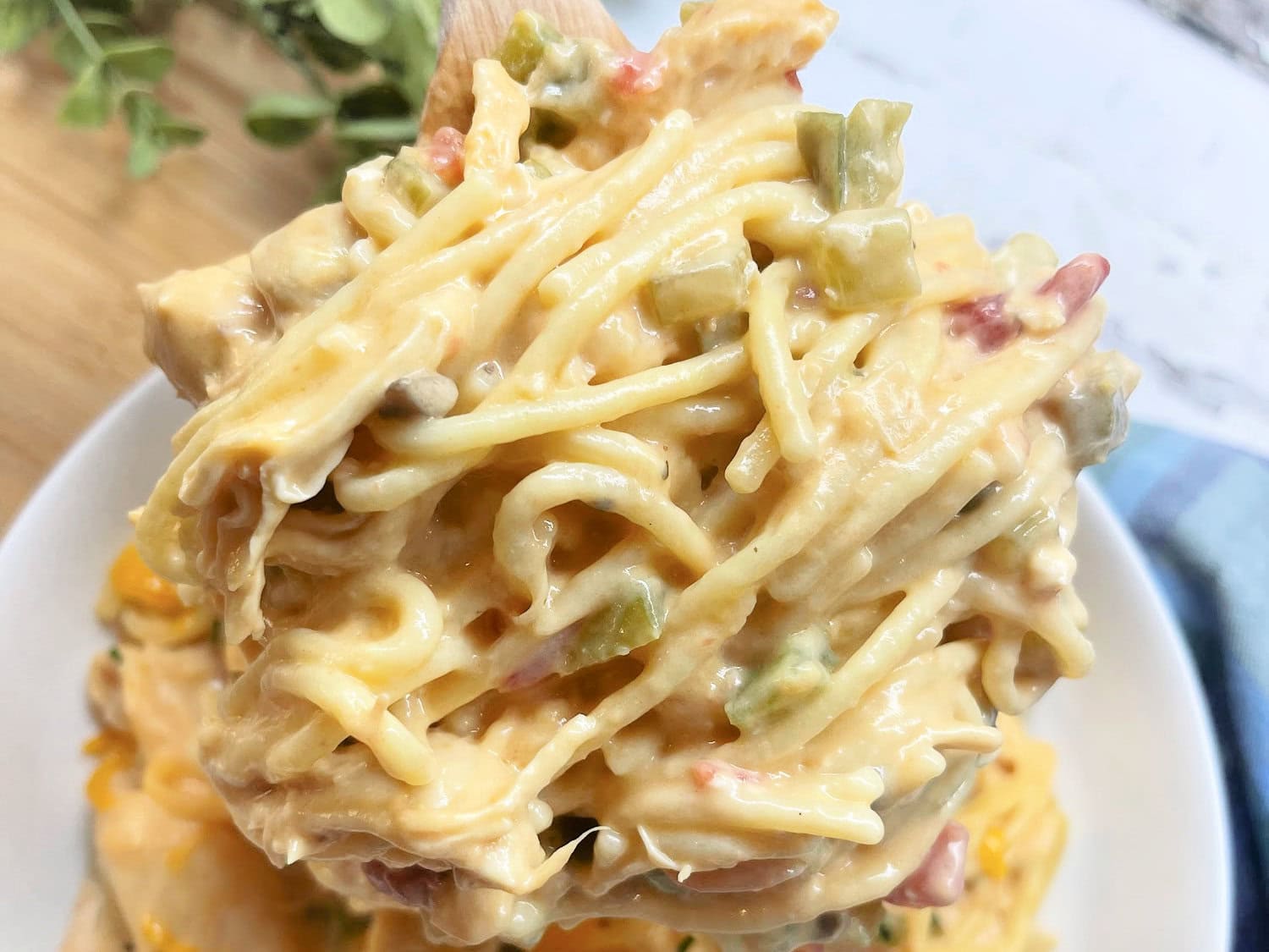 Easy crockpot chicken spaghetti with cheese and Rotel on a spoon. 