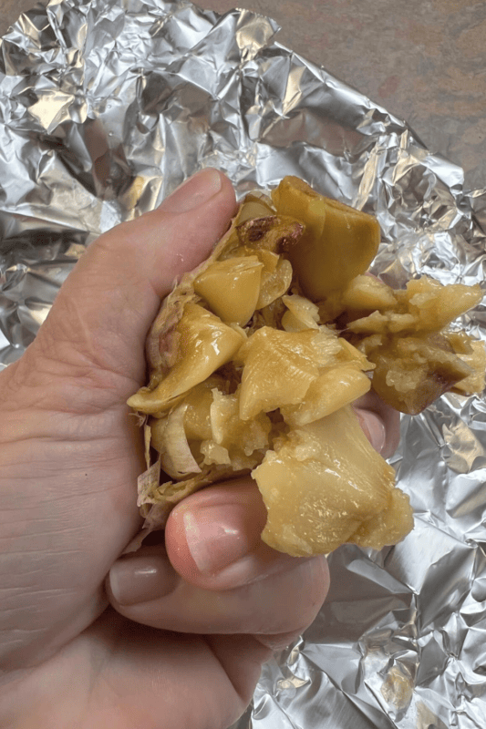 Hand crushing a garlic clove