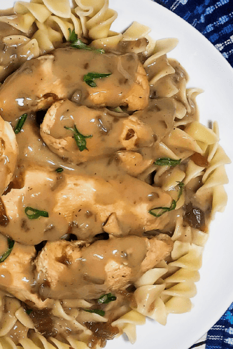 Instant Pot Chicken Tenders over a bed of noodles topped with gravy on in a plate. 