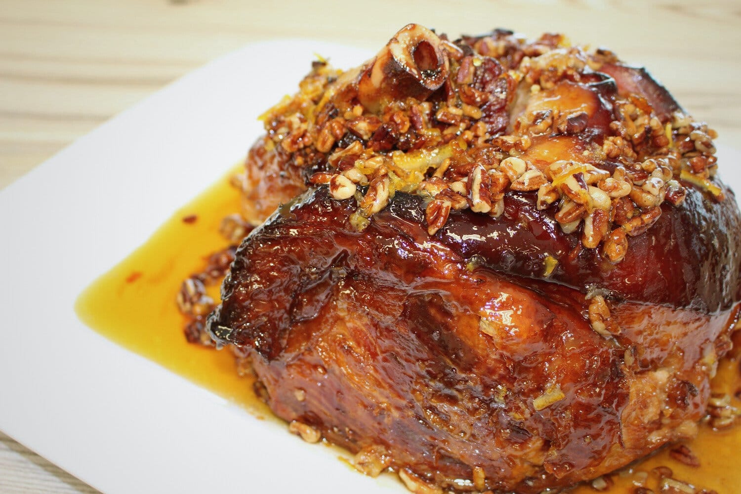 Glazed ham with pecans and maple syrup on a plate. 