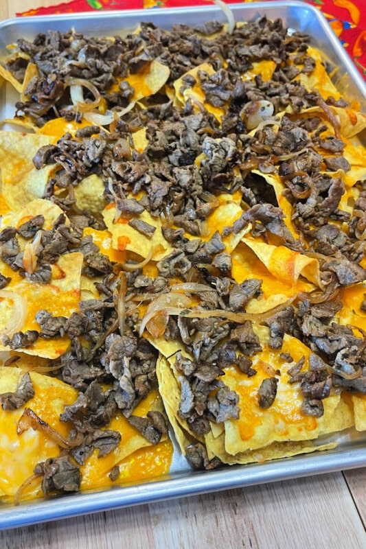Steak sprinkled over melted cheese and tortilla chips. 
