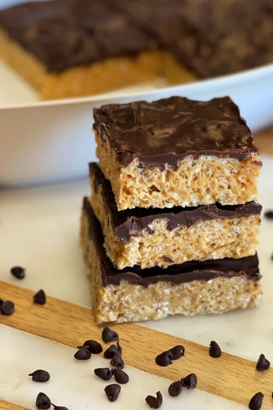 Rice krispie treats stacked beside the pan. 