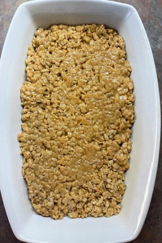 Rice krispie treats mixture pressed into a baking dish. 