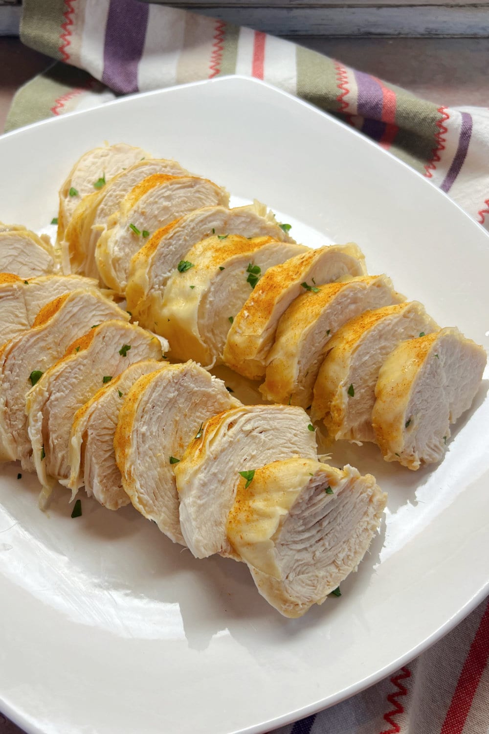 Sliced chicken breasts shingled on a platter. 