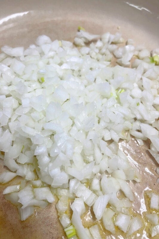 Onions in a skillet ready to sauté in olive oil. 