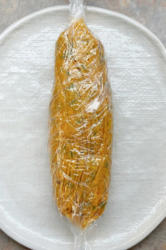 Herb butter wrapped in plastic wrap for refrigeration. 