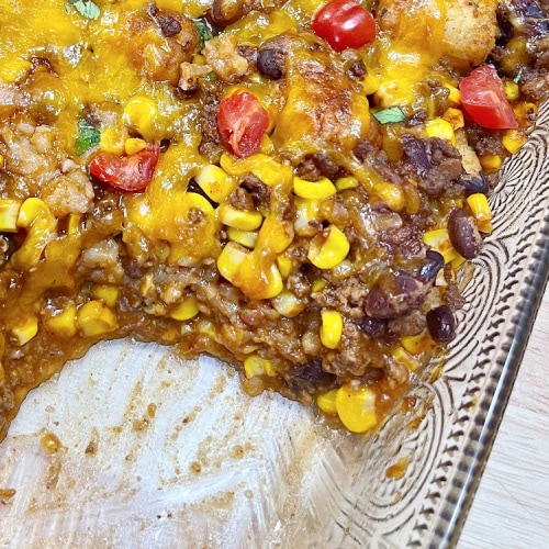 Taco Tater Tot Casserole with a serving removed from the pan.