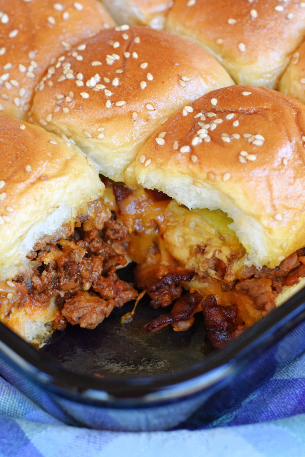 A pan of Bacon Cheeseburger Sliders with one removed from the corner. 