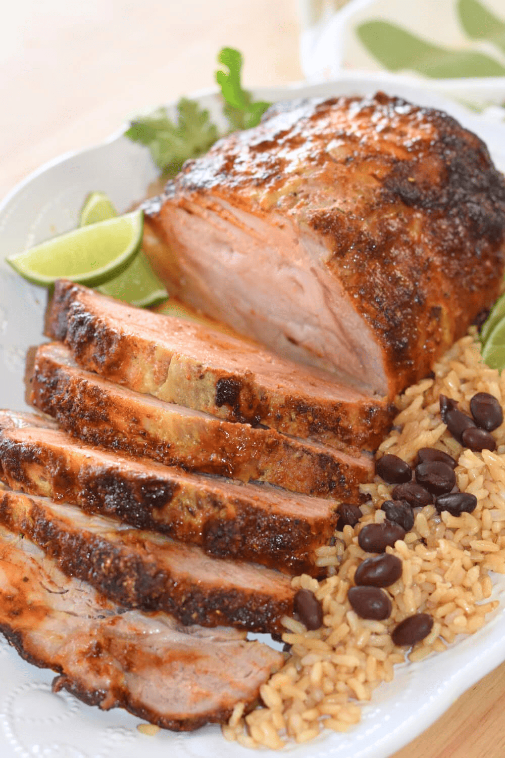 Pork ribeye roast paired with black beans and rice on a platter. 