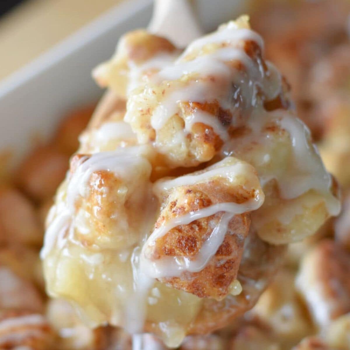 Cinnamon Rolls with Apple Pie filling on a white spoon with icing.