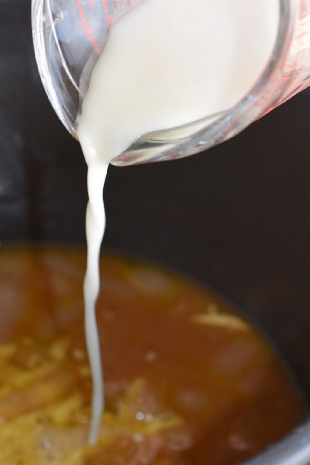 Pouring flour slurry in the liquids to thicken them. 