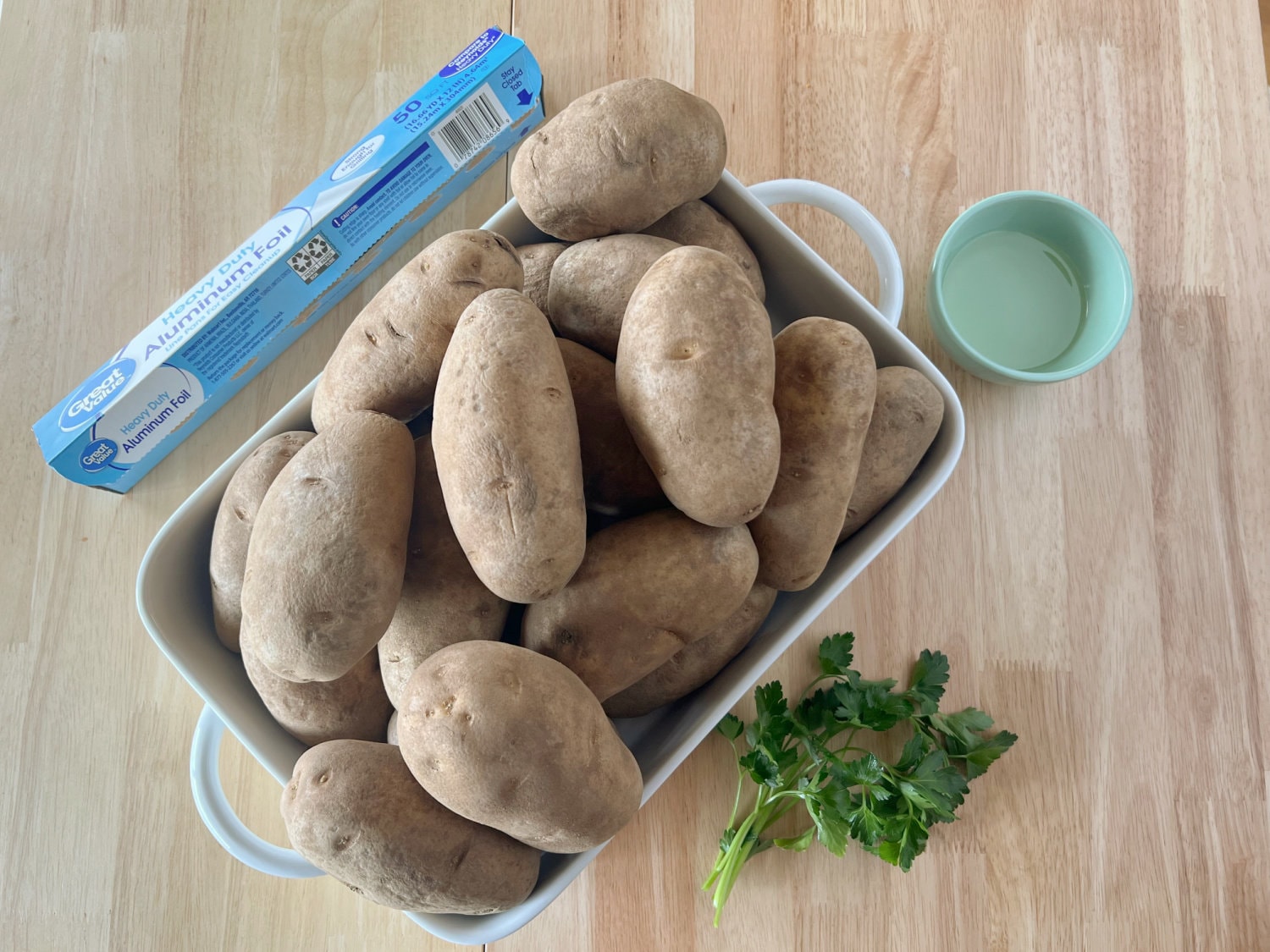 All the ingredients needed to make baked potatoes in a roaster oven. 