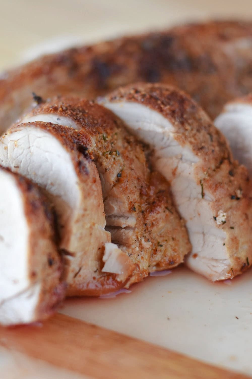 Shingled pork tenderloins laying on a cutting board. 