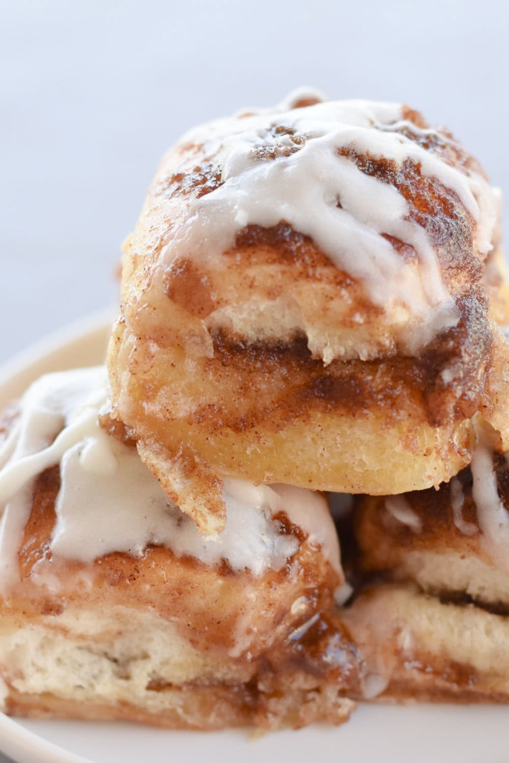 Hawaiian Roll Cinnamon rolls stacked on a white plate. 