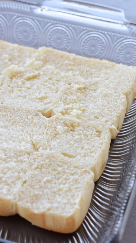 A sheet of Hawaiian rolls placed into a baking dish. 