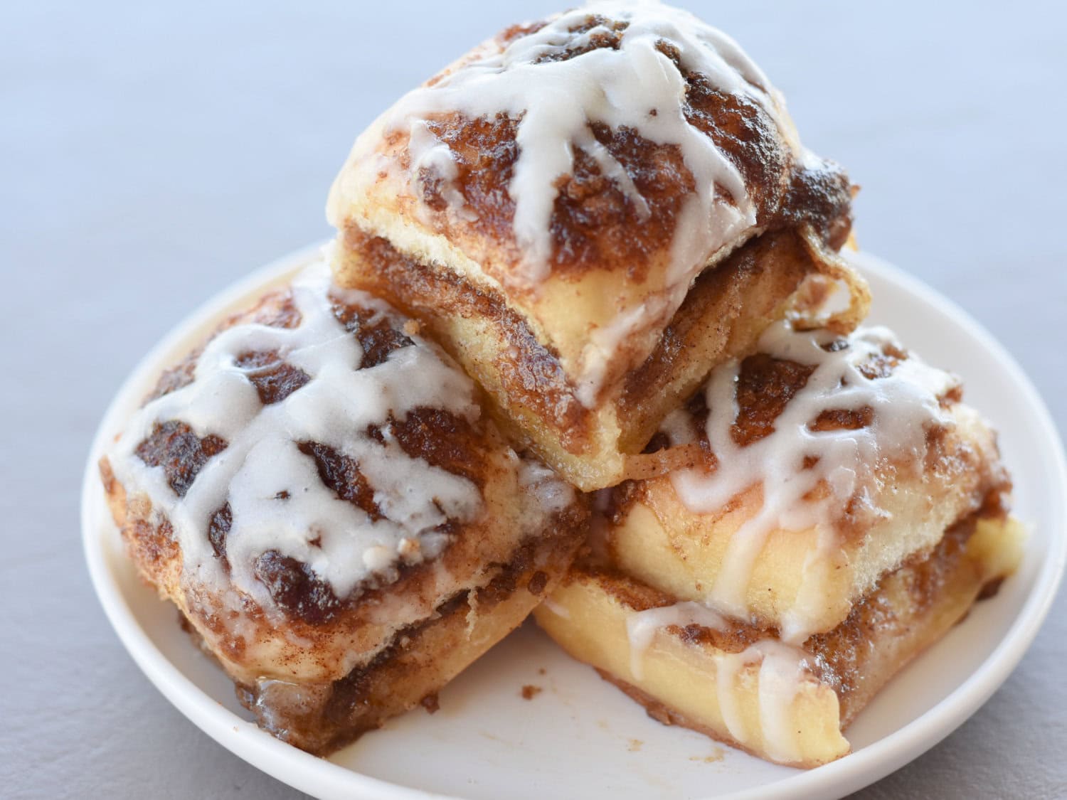 Piled high, Hawaiian Roll Cinnamon Rolls on a white serving plate. 