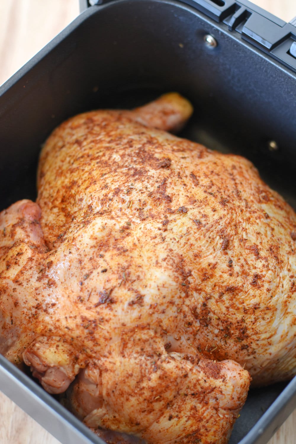 Cooking breast-side-down in air fryer, ready to be flipped.