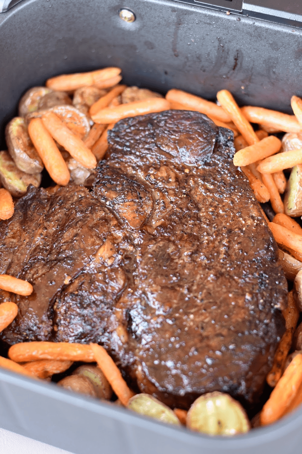 Chuck roast in an air fryer with potatoes and carrots.