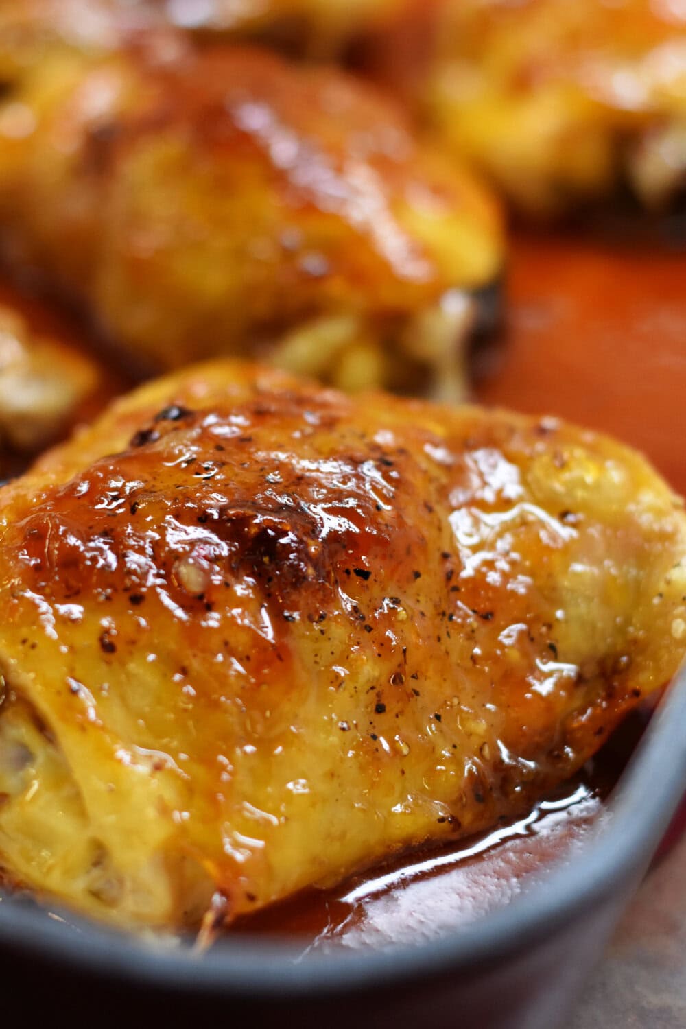 Fully cooked Sticky Asian Chicken Thighs in a baking pan. 