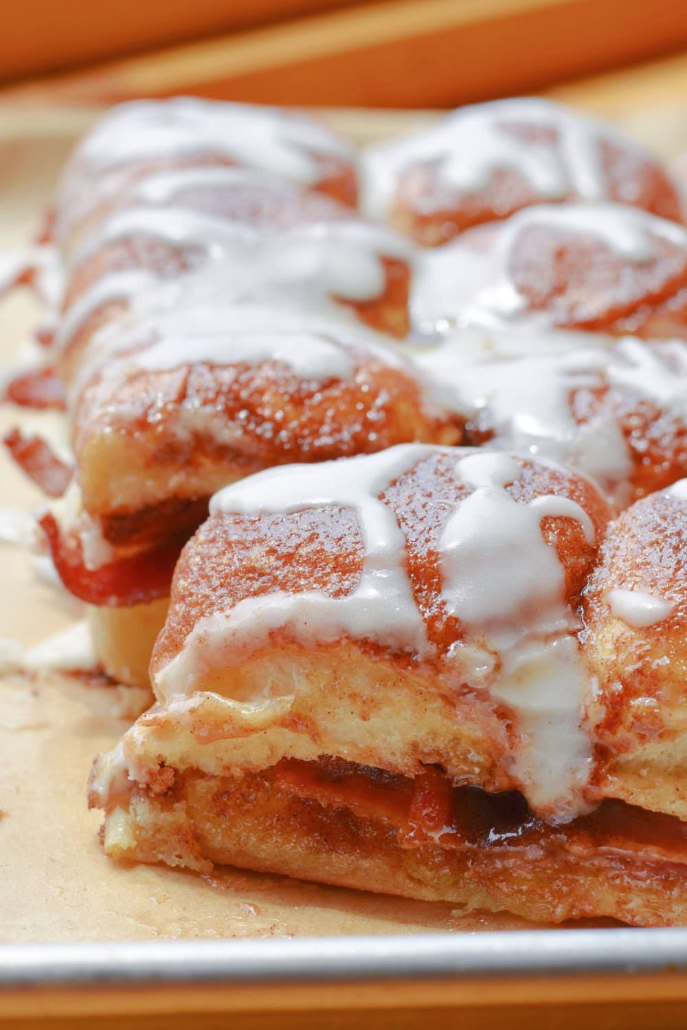 Iced Bacon-Stuffed Cinnamon Rolls on a baking sheet. 