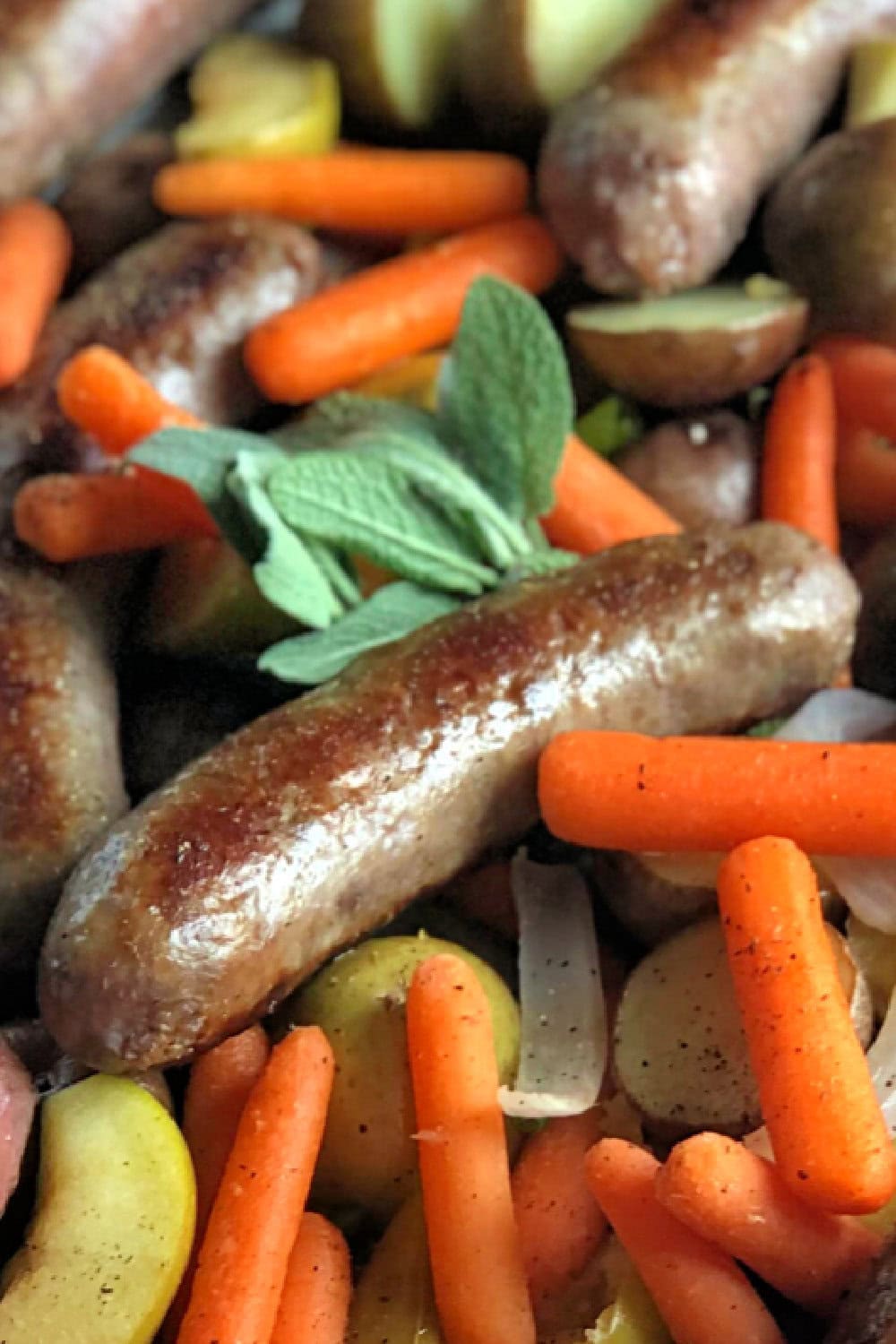 Sausages in a freshly baked with potatoes, onions and carrots. 