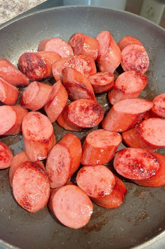 Browning kielbasa in a skillet. 