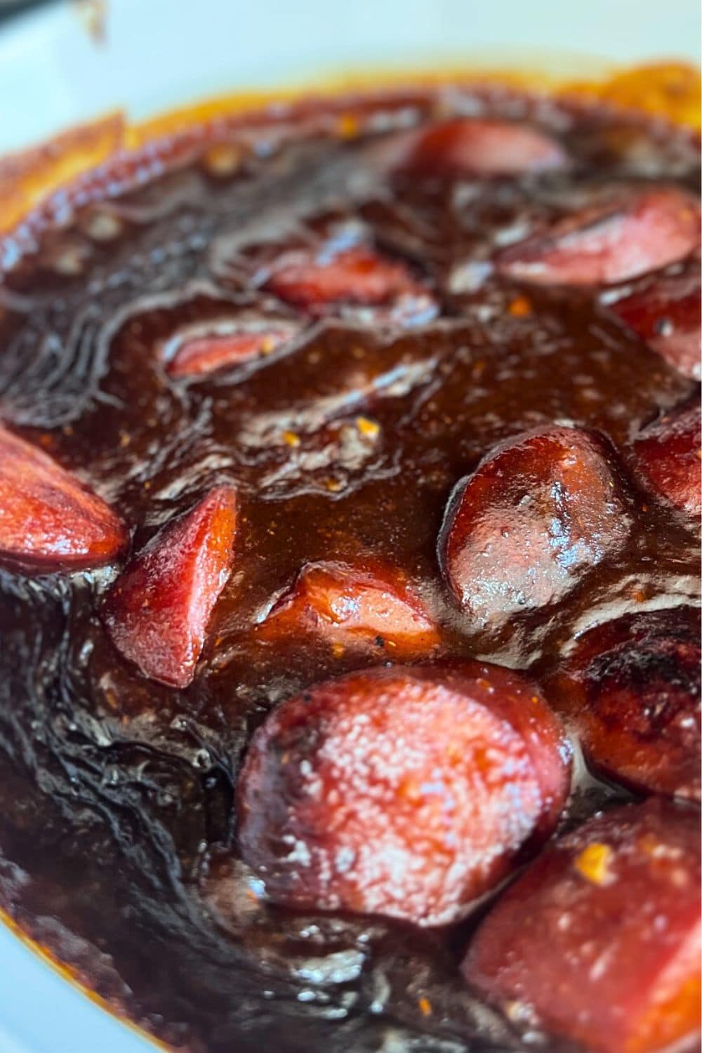 Kielbasa appetizer in bbq sauce and fruit jelly ready to serve for a party. 