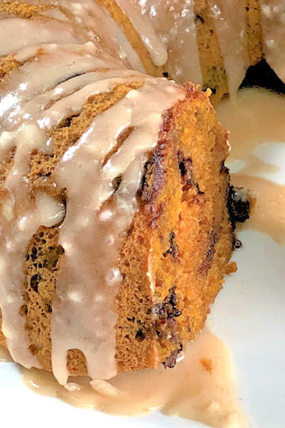 A close up picture of a glazed cake made in the instant pot with pumpkin puree and chocolate chips. 