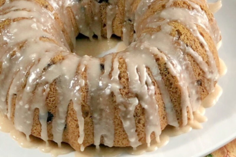 Instant pot pumpkin chocolate cake with a cider glaze on a white plate. 