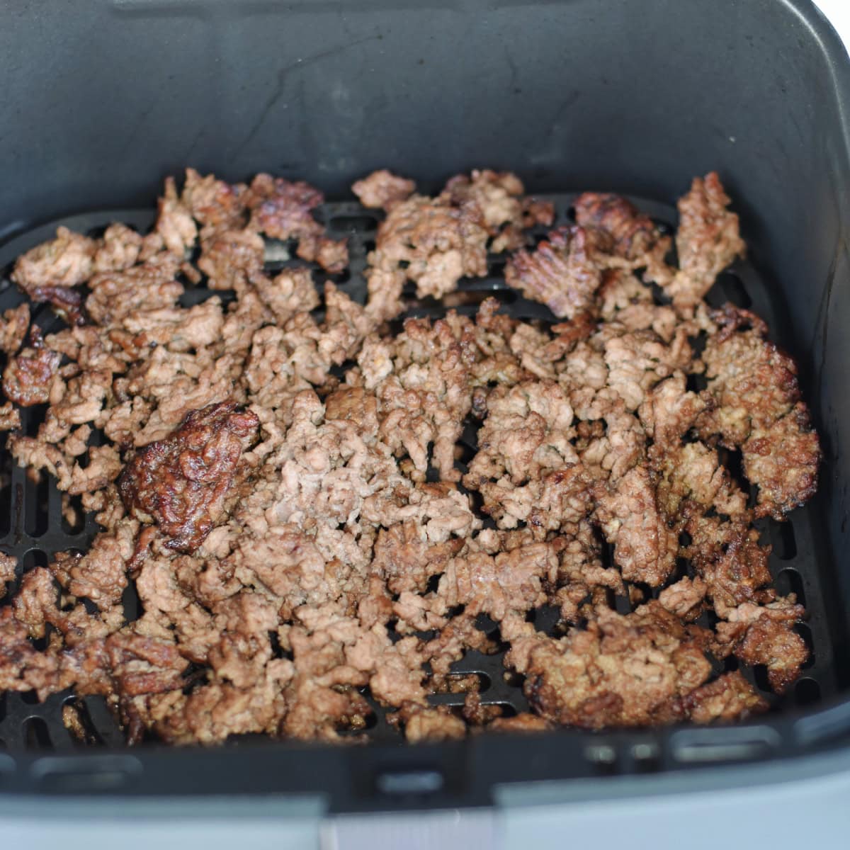 Golden brown cooked ground beef in the air fryer.