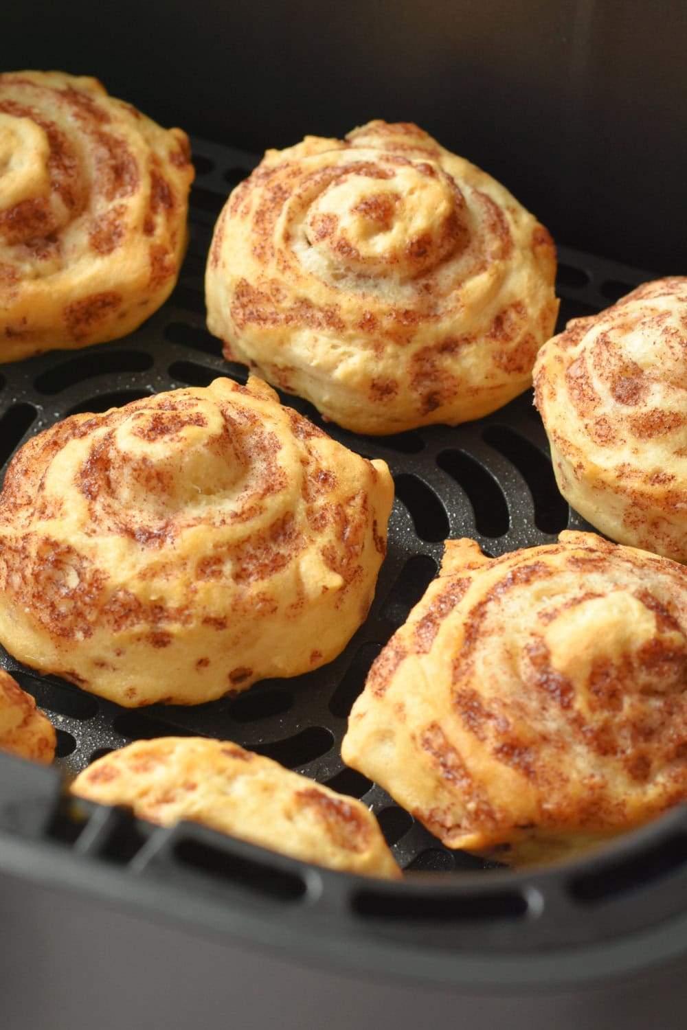 Golden brown cinnamon rolls freshly baked in the air fryer. 