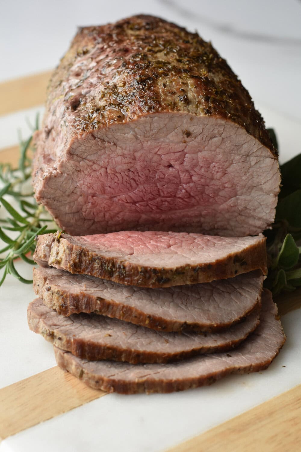 Slices of roast made in the instant pot with garnish on a cutting board. 