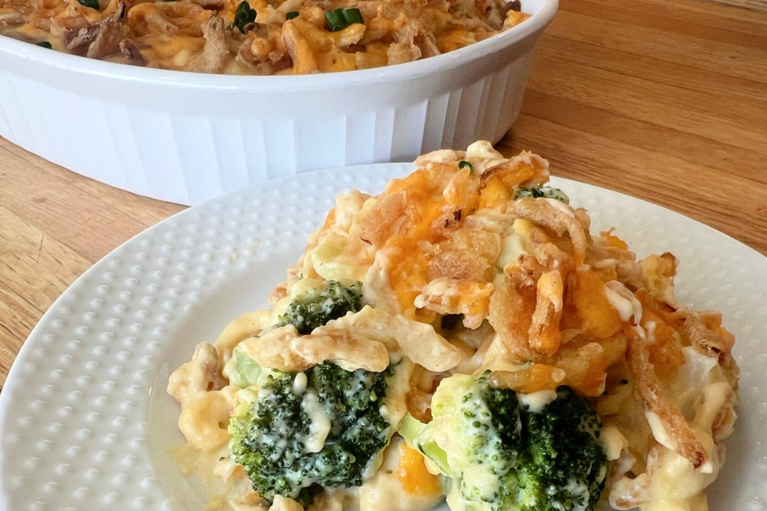 A big spoonful of Broccoli Cauliflower Casserole on a serving plate 